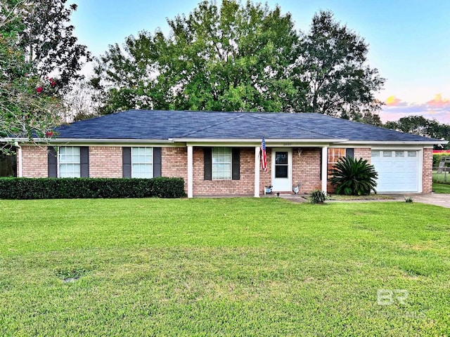 ranch-style home featuring an attached garage, a front yard, and brick siding