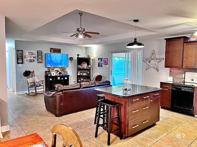 kitchen featuring light tile patterned floors, a breakfast bar area, dishwasher, a tray ceiling, and a kitchen island