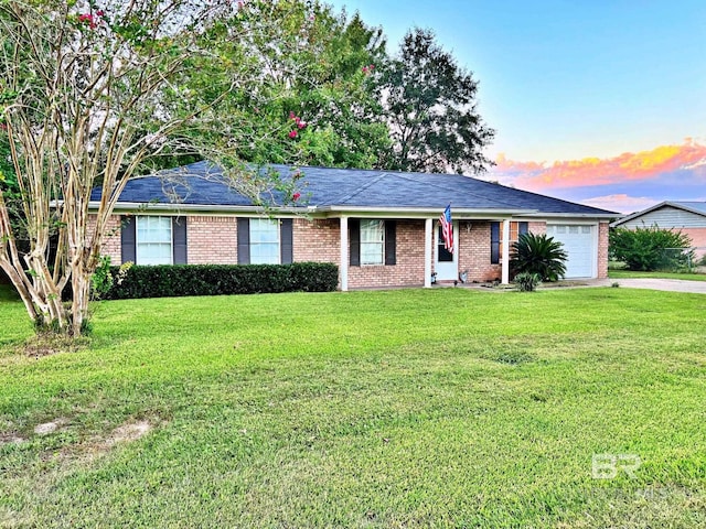 ranch-style house with an attached garage, brick siding, a lawn, and concrete driveway