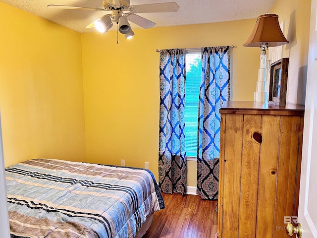 bedroom featuring wood finished floors, ceiling fan, and a textured ceiling