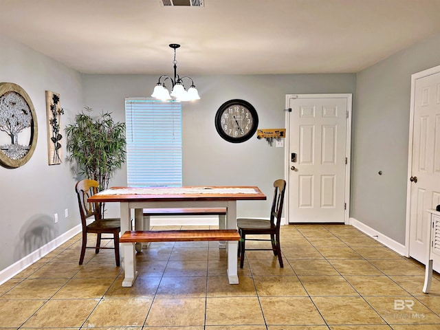 dining space featuring a chandelier, light tile patterned flooring, and baseboards