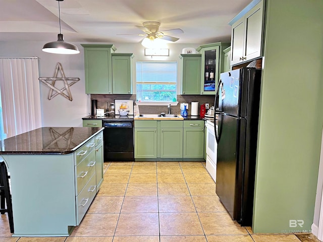 kitchen with green cabinetry, black appliances, a sink, and decorative backsplash