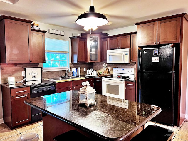 kitchen with sink, a kitchen breakfast bar, a kitchen island, decorative backsplash, and black appliances