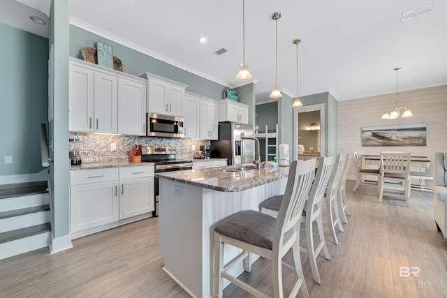 kitchen featuring white cabinets, stainless steel appliances, and a sink