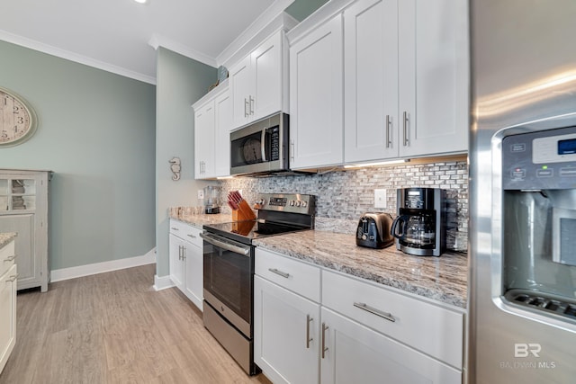 kitchen featuring crown molding, stainless steel appliances, backsplash, white cabinetry, and light stone countertops