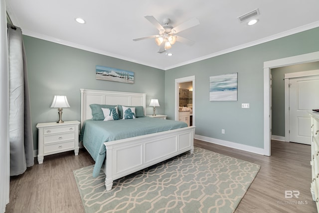 bedroom featuring visible vents, crown molding, and light wood-style flooring