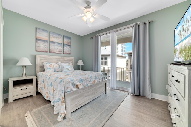 bedroom with access to exterior, a ceiling fan, baseboards, and light wood-style floors