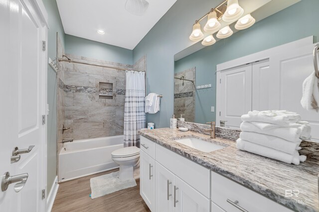 full bathroom with shower / tub combo with curtain, vanity, toilet, and wood finished floors