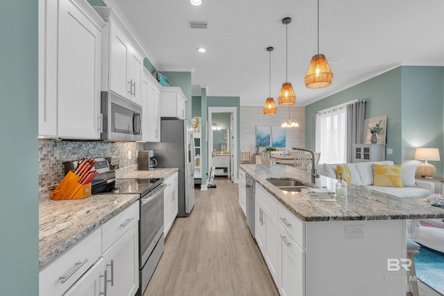 kitchen with stainless steel appliances, a sink, white cabinets, a breakfast bar area, and tasteful backsplash