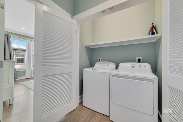 washroom with light wood-type flooring, laundry area, and independent washer and dryer