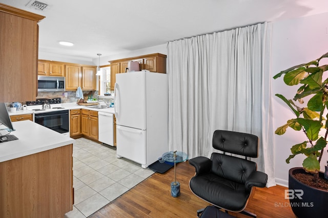 30577 Baldwin St, Perdido Beach, AL 36530 - kitchen featuring white appliances, light countertops, pendant lighting, a sink, and light tile patterned flooring