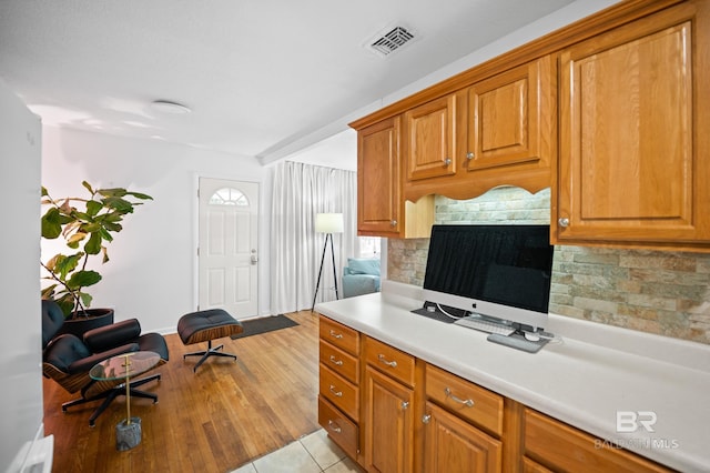 30577 Baldwin St, Perdido Beach, AL 36530 - kitchen with backsplash, light countertops, brown cabinets, baseboards, and light wood-type flooring