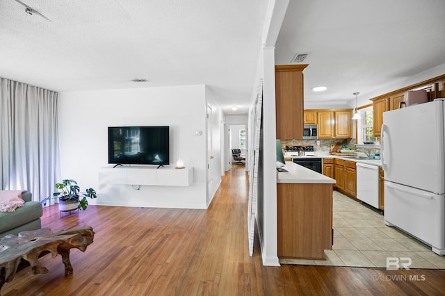 30577 Baldwin St, Perdido Beach, AL 36530 - kitchen featuring white appliances, a sink, light countertops, open floor plan, and pendant lighting