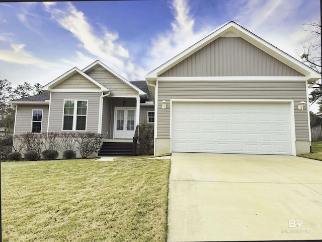 view of front of property with a garage, a front yard, driveway, and french doors