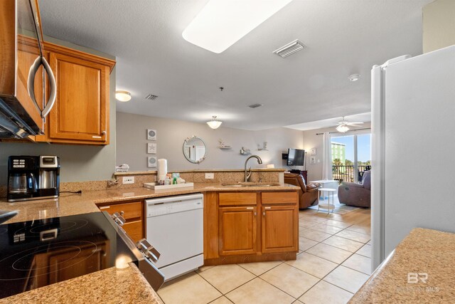 kitchen with kitchen peninsula, appliances with stainless steel finishes, ceiling fan, sink, and light tile patterned floors