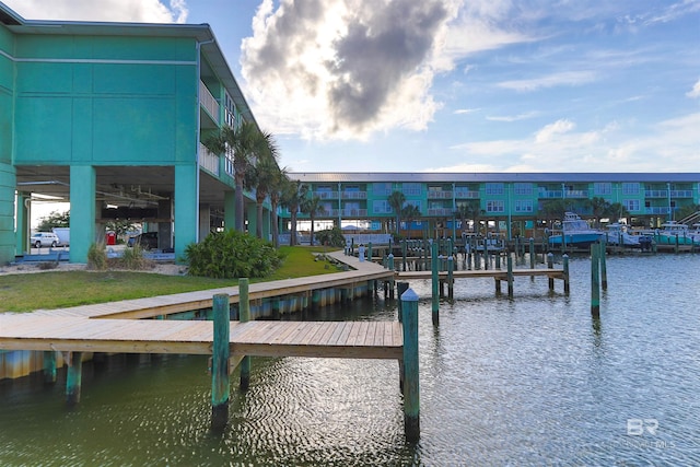 view of dock featuring a water view and a lawn