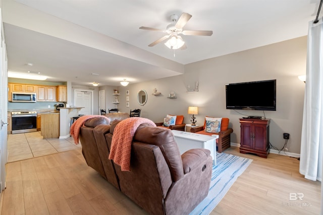 living room featuring ceiling fan and light hardwood / wood-style flooring