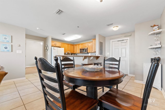 dining area with sink, electric panel, and light tile patterned flooring