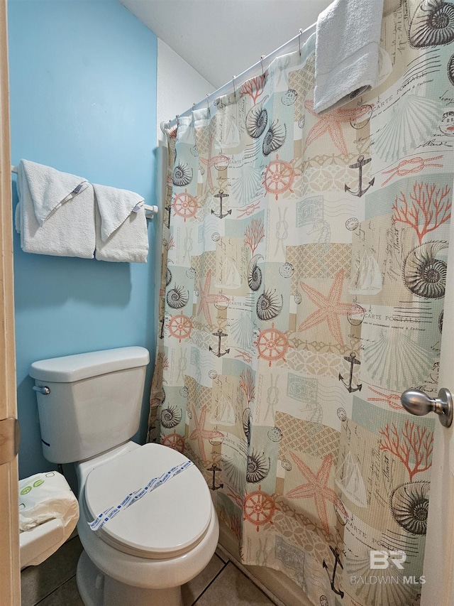 bathroom with toilet, tile patterned flooring, and curtained shower