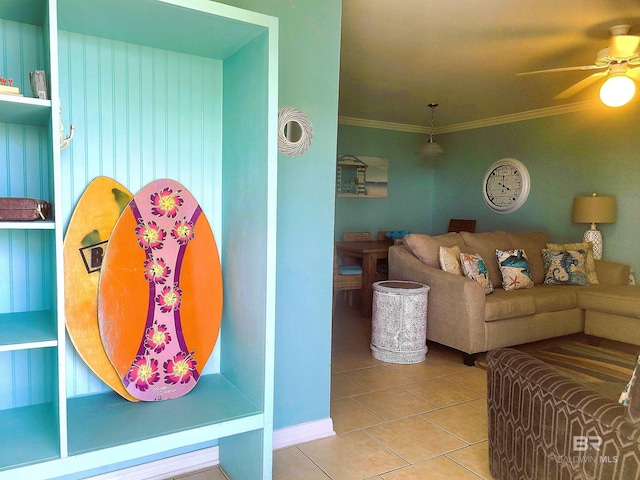 tiled living room with ornamental molding and ceiling fan