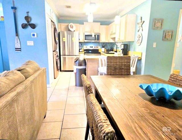 dining space featuring sink, ornamental molding, and light tile patterned floors