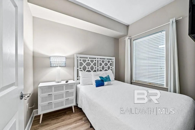 bedroom featuring wood finished floors and baseboards