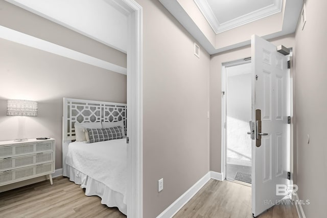 foyer with visible vents, baseboards, crown molding, and wood finished floors