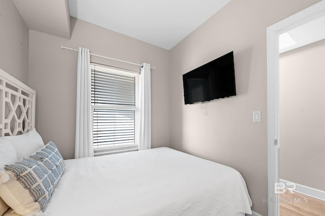 bedroom with baseboards and wood finished floors