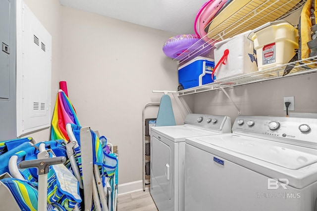 laundry area with laundry area, independent washer and dryer, light wood-style flooring, and baseboards