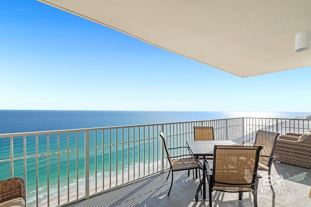 balcony with a water view and outdoor dining space