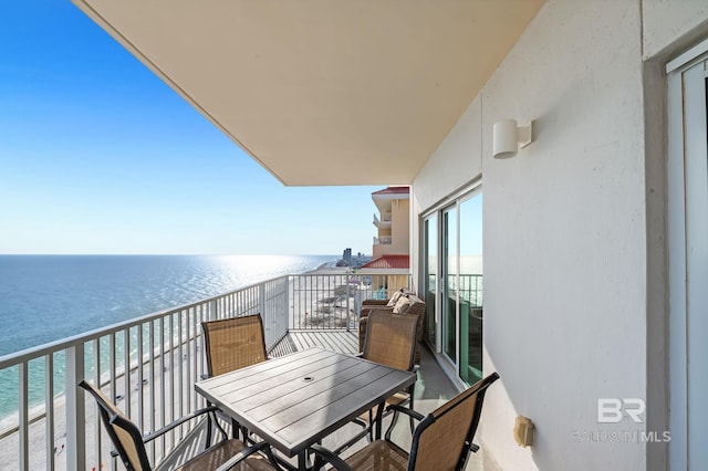 balcony featuring a beach view and a water view