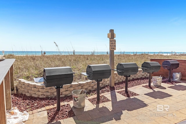 view of patio featuring a water view and a beach view