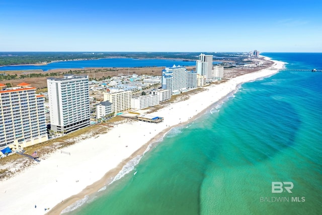 drone / aerial view featuring a view of the beach, a water view, and a view of city