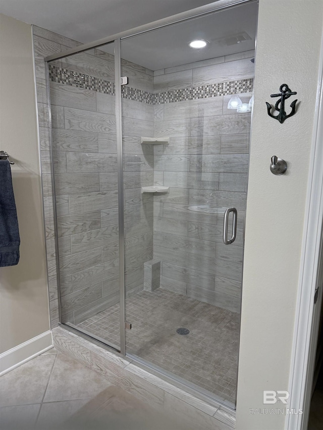full bathroom featuring baseboards, tile patterned flooring, and a stall shower