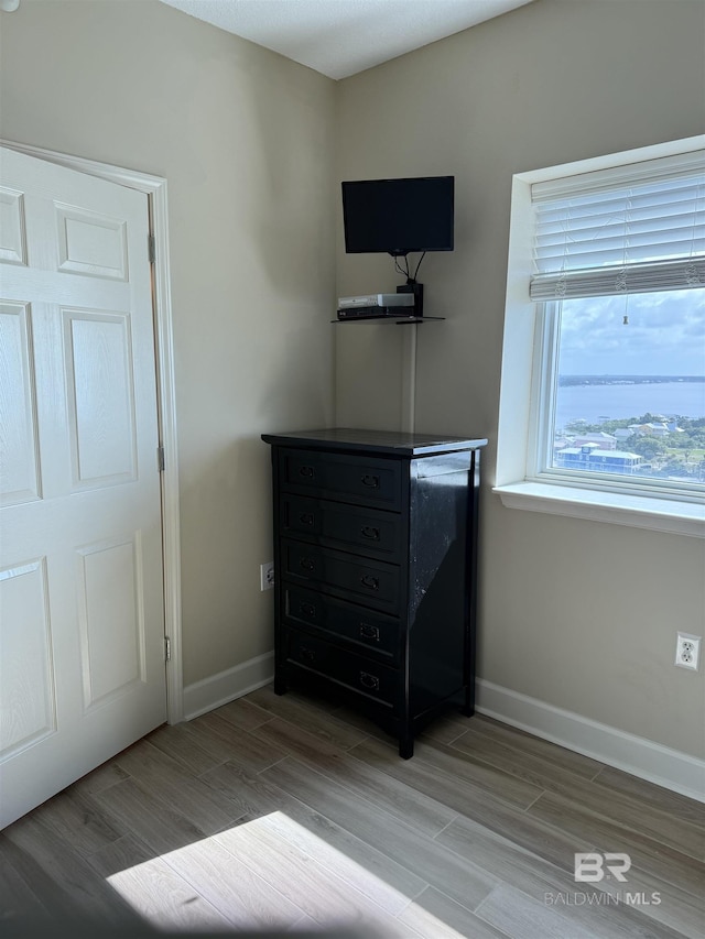 bedroom with baseboards and wood finished floors