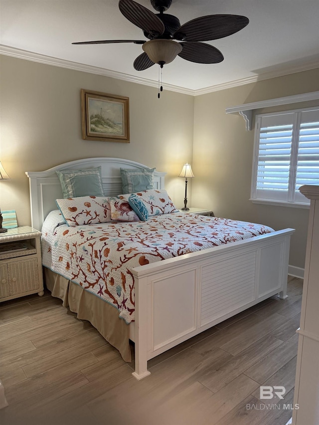 bedroom featuring a ceiling fan, ornamental molding, and light wood finished floors