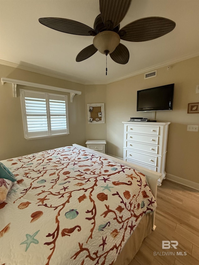 bedroom featuring visible vents, light wood-style floors, crown molding, and ceiling fan