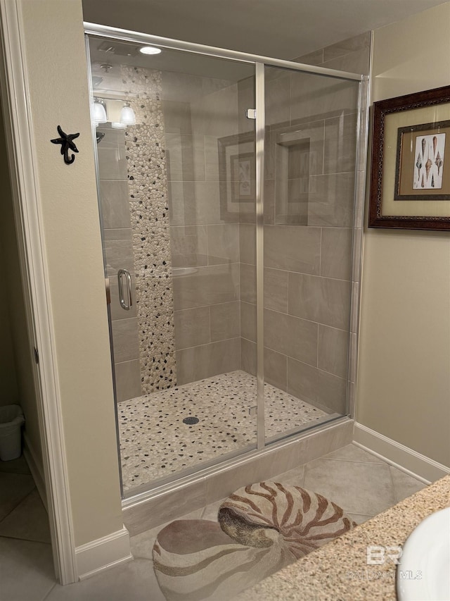 full bath with tile patterned floors, baseboards, and a stall shower