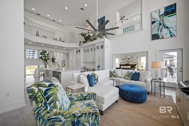 living room featuring a towering ceiling, baseboards, a ceiling fan, and recessed lighting