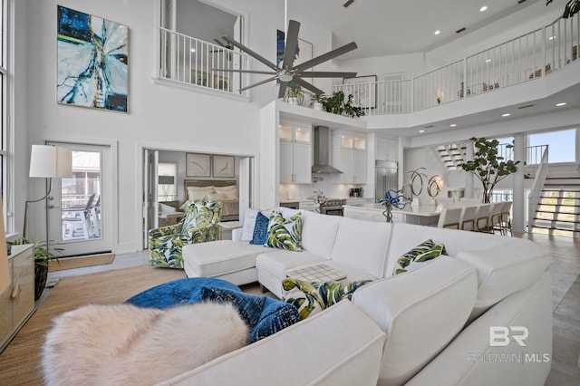 living area featuring a ceiling fan, recessed lighting, and a towering ceiling