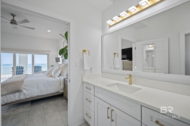 ensuite bathroom with a water view, ensuite bathroom, ceiling fan, vanity, and tile patterned flooring