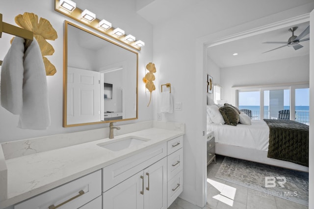 bathroom with a ceiling fan, a water view, connected bathroom, and vanity