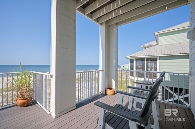 deck with a beach view, a water view, and a sunroom