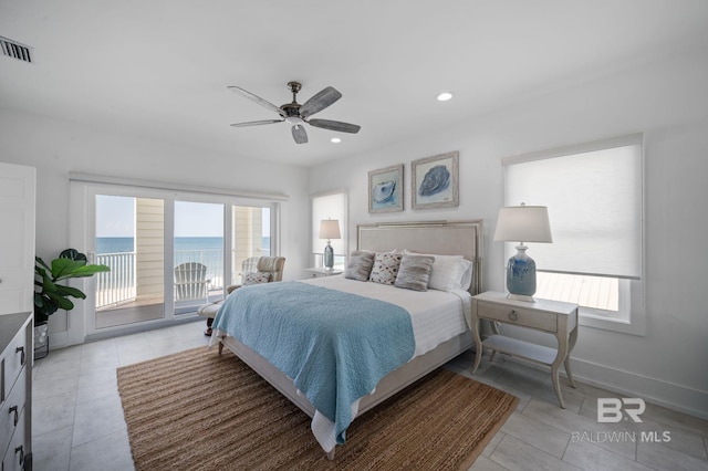 bedroom featuring a water view, access to outside, multiple windows, and visible vents