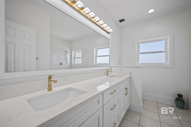 bathroom featuring tile patterned flooring, a healthy amount of sunlight, and a sink