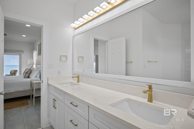 ensuite bathroom with double vanity, a sink, ensuite bath, and tile patterned floors