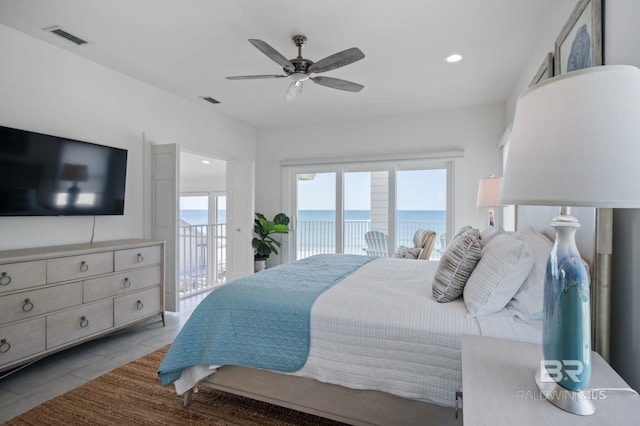 bedroom featuring access to outside, a water view, ceiling fan, and visible vents