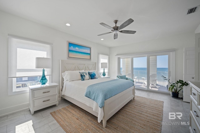 bedroom with recessed lighting, a water view, visible vents, baseboards, and access to outside