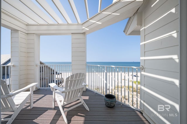 balcony with a water view and a view of the beach