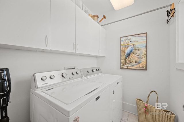 laundry area featuring light tile patterned floors, washing machine and dryer, and cabinet space